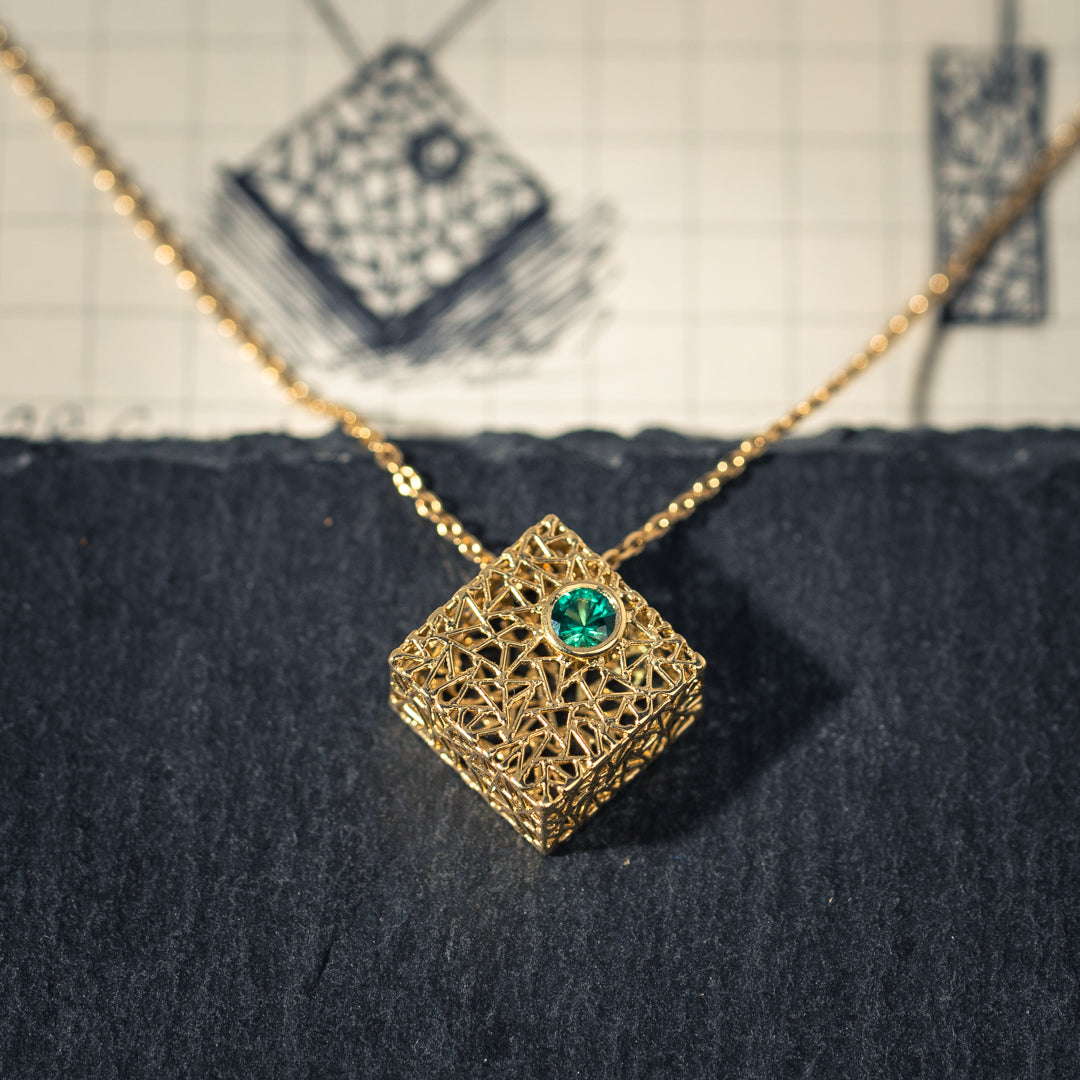 Gold box pendant with emerald